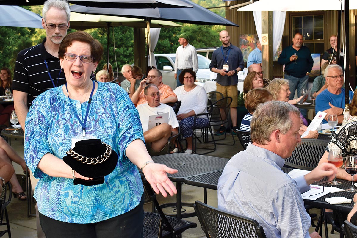 A woman holding a necklace to be auctioned
