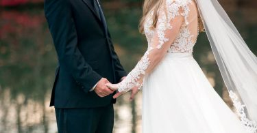 wedding day holding hands by a lake