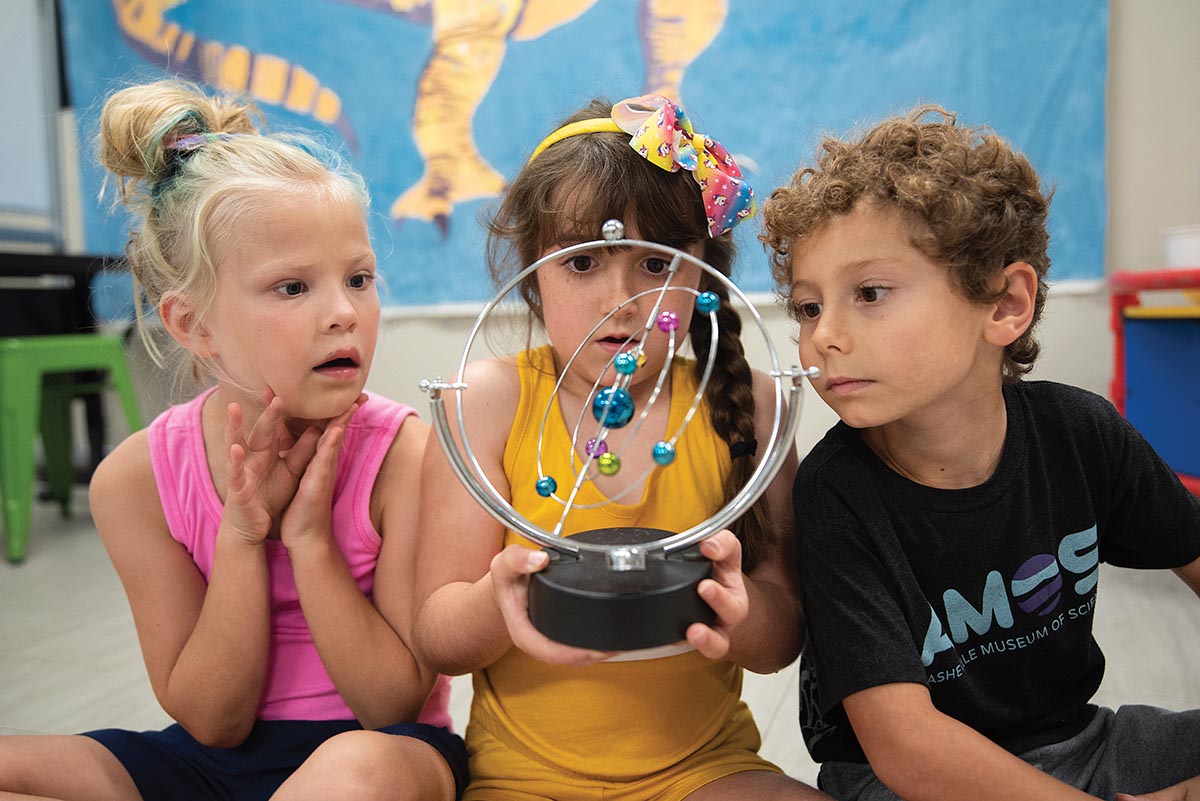 Children looking at a model of the solar system