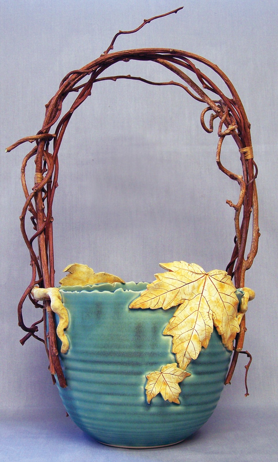 Hand thrown ceramic basket with grapevine handle and ceramic leaf details